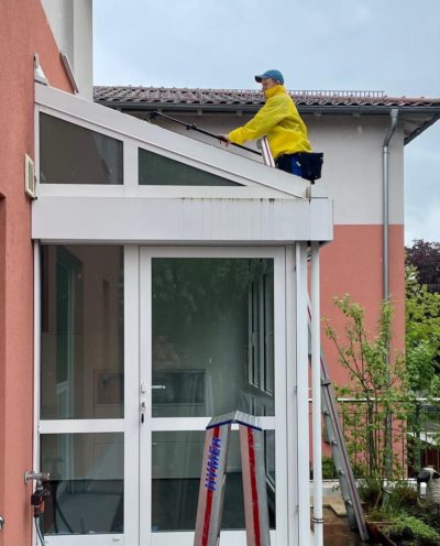 fensterputzer-reinigt-wintergarten-beim-regen-nuernberg