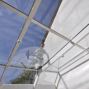 Ein-weitlaeufiges-Glasdach-das-von-einem-professionellen-Fensterputzer-gereinigt-wird.