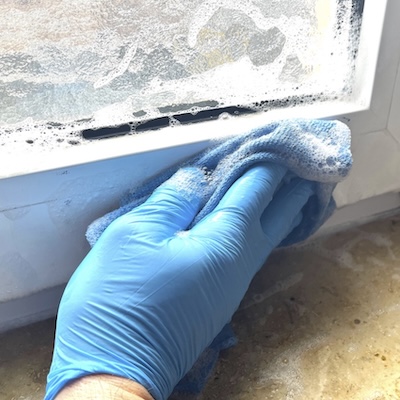 Fensterputzen-der-Rahmen-mit-einem-stark-seifigen-Mikrofasertuch.