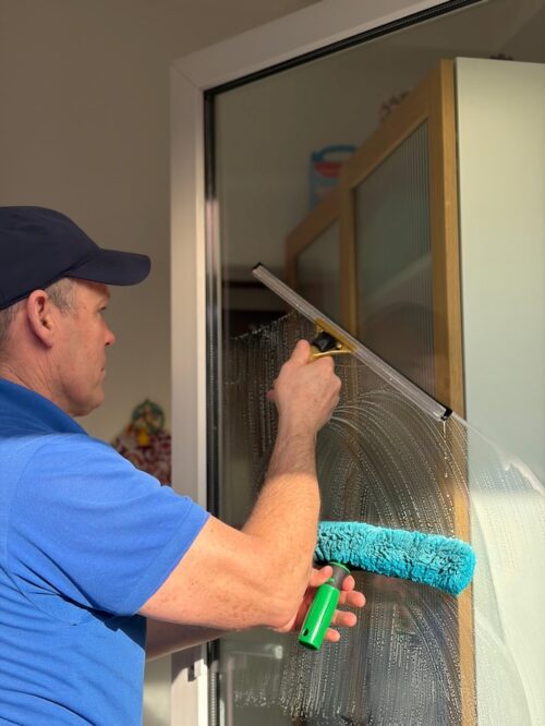 Fensterreinigung-Nuernberg-Fensterputzer-beim-Fensterputzen-in-einem-Privathaus